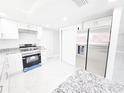Updated kitchen featuring stainless steel appliances, granite countertops, and ample storage in white cabinets at 7740 Sagebrush Dr, Port Richey, FL 34668