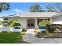 Inviting entrance with a paved walkway leading to double front doors and lush landscaping at 8195 Wooden Dr, Spring Hill, FL 34606