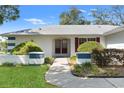 Inviting entrance with a paved walkway leading to double front doors and lush landscaping at 8195 Wooden Dr, Spring Hill, FL 34606