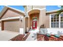Home's front entrance showing a red front door and a landscaped yard at 8603 Sandy Plains Dr, Riverview, FL 33578