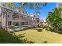 Large backyard with artificial grass, privacy fence, screened in porch, and sparkling pool at 102 Adriatic Ave, Tampa, FL 33606