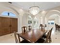 Elegant dining room with marble floors, decorative columns, and a crystal chandelier at 102 Adriatic Ave, Tampa, FL 33606