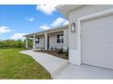 Inviting single-story home featuring a covered porch, tidy landscaping, and a spacious two-car garage at 10493 Grail Ave, Englewood, FL 34224