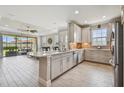 Bright kitchen boasting an island, stainless steel appliances, and white tile flooring at 10816 Wendover Dr, Palmetto, FL 34221