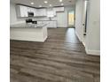 Modern kitchen boasts white cabinets, granite countertops, and stainless steel appliances with wood-look flooring at 112 N Betty Ln, Clearwater, FL 33755