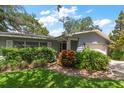 Inviting front entrance with a well-manicured lawn and decorative foliage at 1340 Whispering Pines Dr, Clearwater, FL 33764
