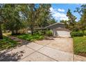 Well-maintained single-story home with a spacious driveway and mature landscaping at 1340 Whispering Pines Dr, Clearwater, FL 33764