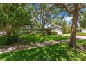 Charming single-story home with lush green lawn and mature trees offering shade at 1340 Whispering Pines Dr, Clearwater, FL 33764