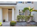 Townhouse exterior featuring a palm tree, well-maintained facade and manicured bushes at 13777 Forest Lake Dr, Largo, FL 33771
