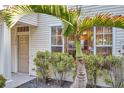 Home exterior featuring tropical landscaping, front door, and well-maintained facade at 13777 Forest Lake Dr, Largo, FL 33771