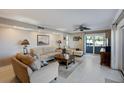 Comfortable living room featuring tile flooring, a ceiling fan, and sliding glass doors to a balcony at 1480 Gulf Blvd # 103, Clearwater Beach, FL 33767