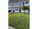 Two-story home with a lush green lawn and a small palm tree at 2050 58Th N Ave # 6, St Petersburg, FL 33714