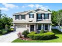 Charming two-story home with a manicured lawn, black shutters, and a welcoming front porch at 27549 Stonecreek Way, Wesley Chapel, FL 33544
