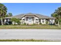 Charming single-story home with a manicured front yard and lush palm trees at 284 Peninsula Ave, Tarpon Springs, FL 34689