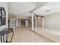 Spacious living room featuring tiled flooring, columns, and ample natural light, seamlessly connecting living spaces at 284 Peninsula Ave, Tarpon Springs, FL 34689