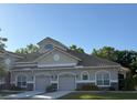 Charming townhouse featuring attached garages, stone accents, and lush landscaping at 29823 Ganga Way, Wesley Chapel, FL 33543