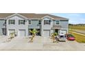 Townhomes with gray exteriors, one-car garages, tidy landscaping, and ample parking at 33105 Major Oak Dr, Wesley Chapel, FL 33545