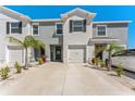 Inviting townhome featuring a clean gray exterior, one-car garage and tidy landscaping at 33105 Major Oak Dr, Wesley Chapel, FL 33545