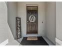 Stylish front door with a decorative wreath and welcome sign, offering a warm entrance at 33105 Major Oak Dr, Wesley Chapel, FL 33545
