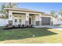 Single Gathering home featuring a lush lawn, white exterior paint, and a brick paved driveway at 3326 W Heiter St, Tampa, FL 33607