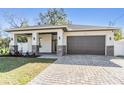Charming single Gathering home featuring a two car garage, stone accents, and a covered front porch at 3326 W Heiter St, Tampa, FL 33607