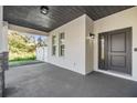 Covered front porch featuring a dark gray front door, black exterior lighting, and stone accents at 3326 W Heiter St, Tampa, FL 33607