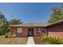Charming brick home with a welcoming front door and landscaped front yard and walkway at 35109 Excalibur, Webster, FL 33597