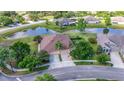 Aerial view of a well-maintained home with pond, lush landscaping and a two-car garage at 4235 Angelica Loop, Wesley Chapel, FL 33543