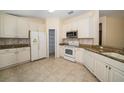 Bright kitchen features white cabinets, granite countertops, and stainless steel appliances at 4235 Angelica Loop, Wesley Chapel, FL 33543