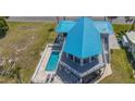 Aerial view of home with pool and patio area, light-blue metal roof and white fencing at 4275 Bellaire Dr, Hernando Beach, FL 34607