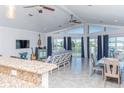 Open-concept living room with tile floors, a vaulted ceiling, and expansive waterfront views at 4275 Bellaire Dr, Hernando Beach, FL 34607