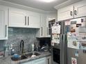 Bright kitchen featuring granite countertops, stainless steel refrigerator, and ample cabinet space at 4503 W Minnehaha St, Tampa, FL 33614