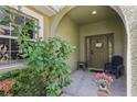 Inviting front porch with plants, wreath on door and a chair creating a warm and welcoming entrance to the home at 8125 Stone Path Way, Tampa, FL 33647