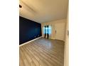 A living room with wood-look tile flooring and a dark blue accent wall at 9618 N 13Th St, Tampa, FL 33612