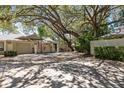 Inviting single-story home with mature trees, an American flag, and a two-car garage at 110 Parkside Colony Dr, Tarpon Springs, FL 34689