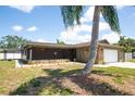 Single story home with screened in porch and a large palm tree at 11797 David Ct, Largo, FL 33778