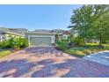 Inviting single-Gathering home with lush landscaping, a two-car garage, and a paver driveway at 12206 Blue Pacific Dr, Riverview, FL 33579