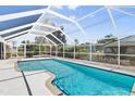 A refreshing screened-in pool with clear blue water and a serene backyard setting for relaxation and enjoyment at 170 Argus Rd, Venice, FL 34293