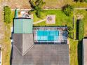 Aerial view of a home with a large screened pool, landscaped yard with fire pit, and a fenced backyard at 18836 Green Park Rd, Hudson, FL 34667