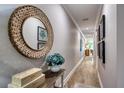 Long hallway with wood-look flooring, decor and art; a decorative mirror reflects light, creating an inviting space at 19817 Gulf Blvd # 602, Indian Shores, FL 33785