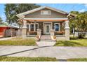 Inviting single-story home featuring a classic craftsman design, enhanced by a covered porch and lush landscaping at 2224 Gordon St, Tampa, FL 33605