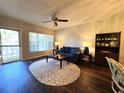 Cozy living room featuring a large window, ceiling fan, blue sofa, and a unique oval rug at 2253 Norwegian Dr # 63, Clearwater, FL 33763