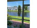 Scenic patio view of a serene pond and lush greenery with other units across the water at 244 Countryside Key Blvd, Oldsmar, FL 34677
