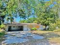 Single-story home with an attached carport and a boarded up window at 312 N Manhattan Ave, Tampa, FL 33609