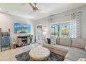 Living room with large sectional, decorative fireplace, ceiling fan, and natural light at 3158 Victoria Inlet Dr, Holiday, FL 34691