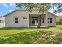 Exterior of home with grassy backyard, patio and sliding glass doors at 3527 101St E Ave, Parrish, FL 34219