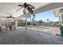 Covered patio with ceiling fans overlooking a canal. The patio includes a paver floor and in-ground pool at 3807 48Th S Ave, St Petersburg, FL 33711