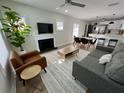 Bright living room featuring a fireplace, modern furnishings, and an open layout to the dining and kitchen areas at 3910 N Suwanee Ave, Tampa, FL 33603