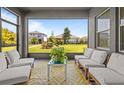 Relaxing screened patio with ample seating and views of the fenced backyard and neighboring homes at 4528 Ballantrae Blvd, Land O Lakes, FL 34638