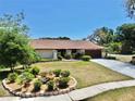 Inviting home with manicured lawn, decorative flower beds, and a concrete driveway at 501 Sportsman Park Dr, Seffner, FL 33584